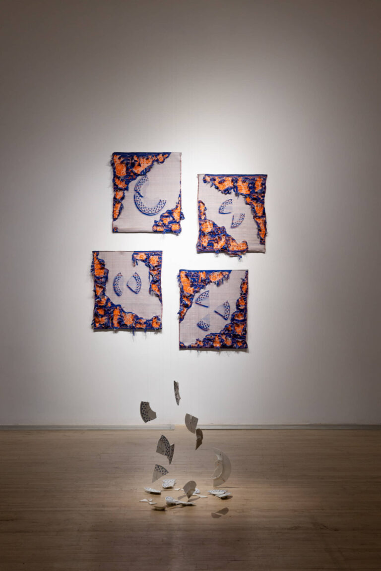 Agathe Dessaux, 300, rue de l’Égalité, 2025, installation, textile et porcelaine, tissage Jacquard, fils de coton, assiettes du service à vaisselle de son enfance, perles de verre. Photo : Annie France Leclerc