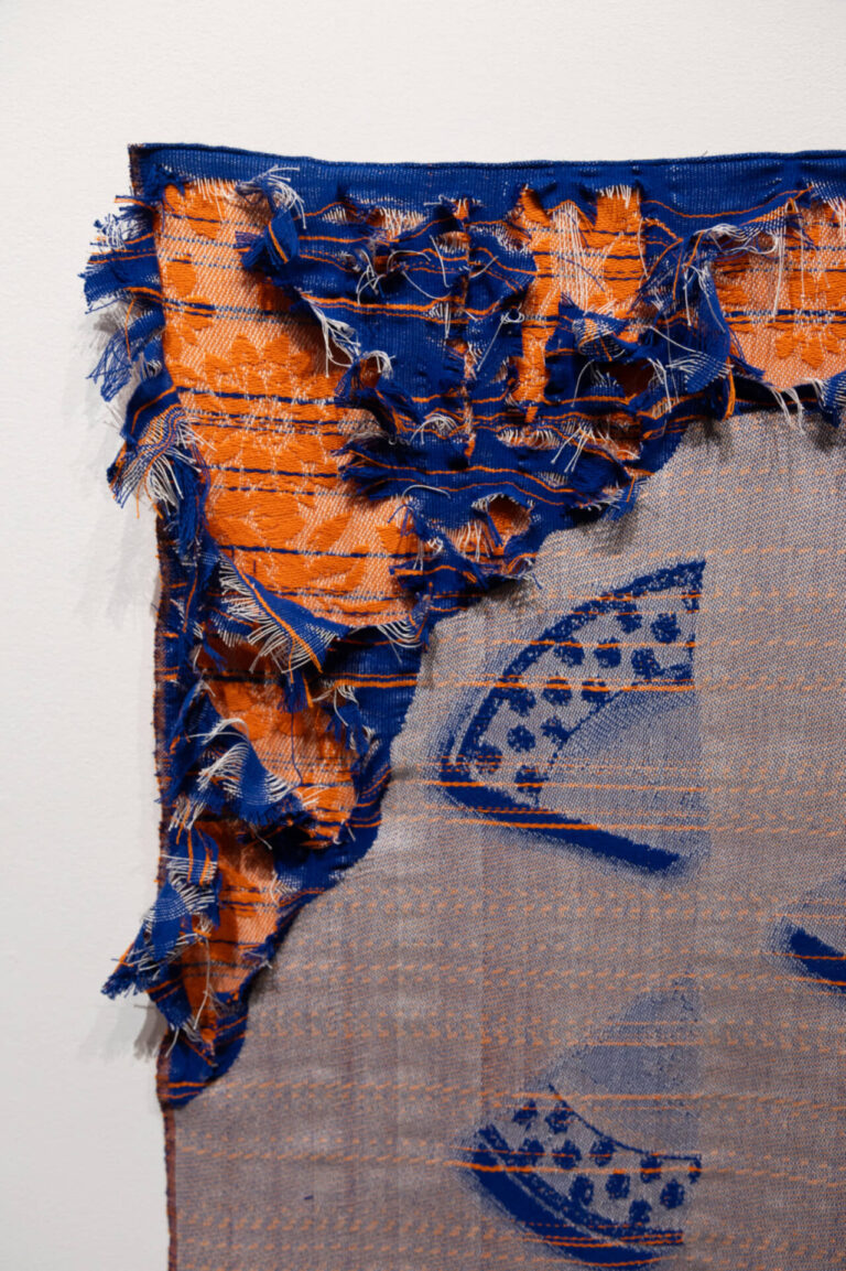 Agathe Dessaux, 300, rue de l’Égalité, 2025, installation, textile et porcelaine, tissage Jacquard, fils de coton, assiettes du service à vaisselle de son enfance, perles de verre. Photo : Annie France Leclerc