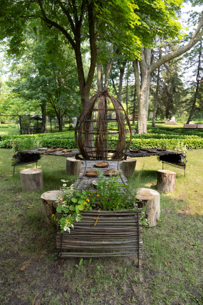 André Boisvert, Vivre à table, 2025, sculpture rassembleuse, métal recyclé, tige de saule, fines herbes et fleurs comestibles.